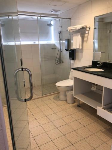 a bathroom with a glass shower and a toilet at Ocean Hayline Hotel in Jian