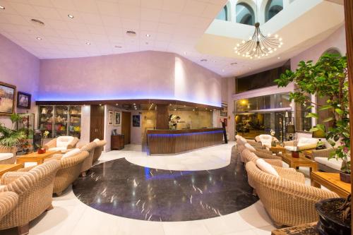 a lobby of a hotel with chairs and a bar at Hotel Alba Seleqtta in Lloret de Mar