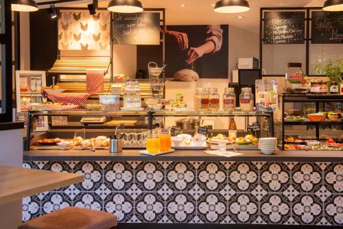 a buffet line with food on display in a restaurant at Hotel Avisa in Karlsruhe