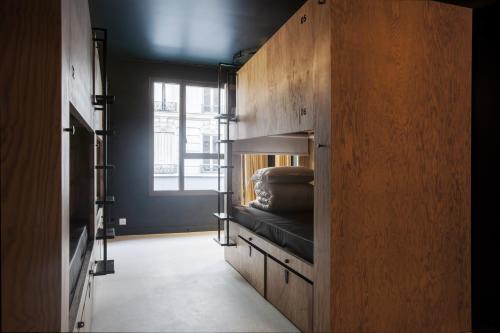 Cette chambre dispose d'un lit superposé dans un mur en bois. dans l'établissement JO&JOE Paris - Nation, à Paris