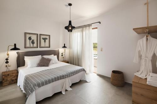 biała sypialnia z łóżkiem i oknem w obiekcie Zen Luxury Home, Family Sea Escape! w mieście Magnisía