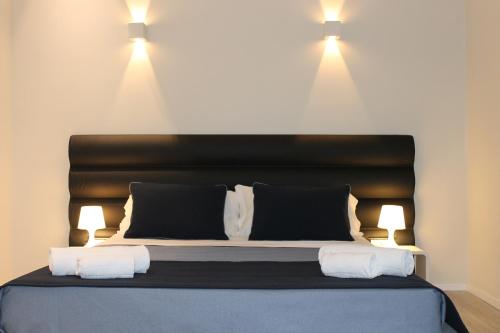a bedroom with a bed with two lights on the wall at Little Rose Lodge in Rome