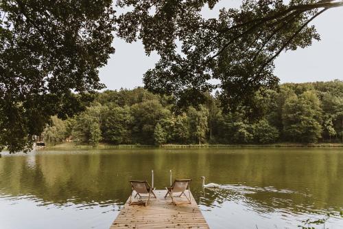 due sedie sedute su un molo in un lago di Falkensteiner Premium Camping Lake Blagus a Sveti Jurij ob Ščavnici