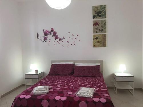 Casa Vacanze Fabrizio في باليستراتي: غرفة نوم بسرير ارجواني مع مواقف ليلتين