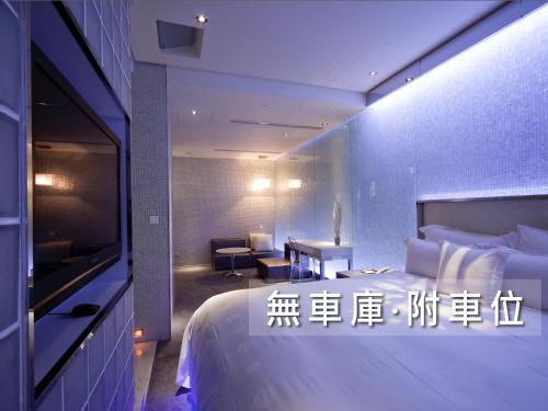 a hotel room with a bed and a table and a desk at Wego Funtel - Dazhi Branch in Taipei