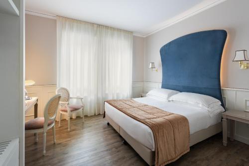 Un pat sau paturi într-o cameră la Hotel San Luca