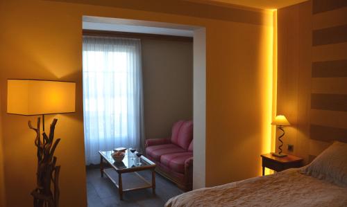 a bedroom with a pink couch and a window at Résidence des Châteaux in Ottrott