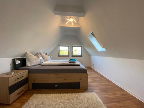 Schlafzimmer mit einem Bett, einer Kommode und einem Fenster in der Unterkunft Urlaub in der Welterbestadt Quedlinburg in Gernrode - Harz