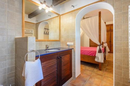 un bagno con lavandino e un letto in una camera di Villa Miguel a Sant Rafel de sa Creu