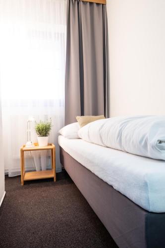 a bedroom with a bed and a table next to a window at Restaurace a penzion U Hasičů in Klimkovice