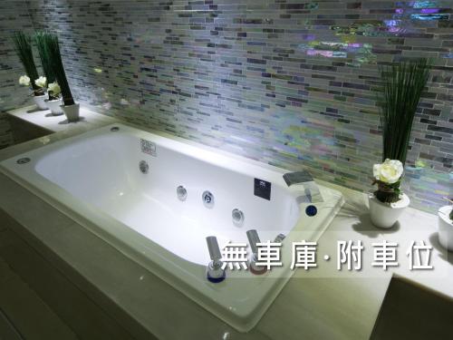a white bath tub sitting next to a white sink at Wego Funtel - Dazhi Branch in Taipei