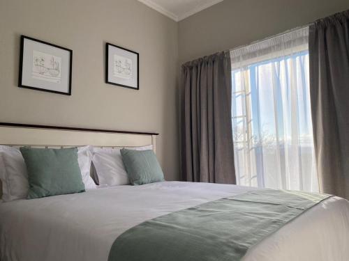 a bedroom with a bed and a large window at Spring Acres Apartment living in Nelspruit