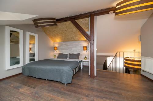 1 dormitorio con 1 cama grande y una escalera en Emporio Prague Apartments, en Praga
