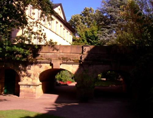 un puente de piedra con arcos frente a un edificio en Kurpark-Residenz Deidesheim en Deidesheim