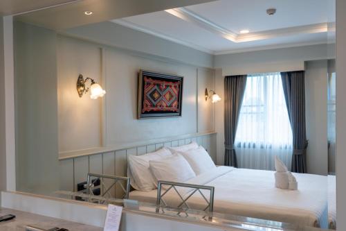 - une chambre d'hôtel avec un lit et un miroir dans l'établissement Rimwiang, à Chiang Mai