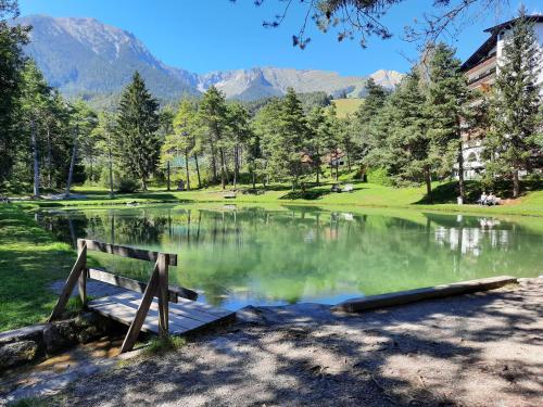 a park bench sitting in front of a lake at Tiroler Bergnestl in Imst