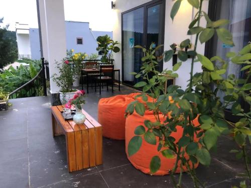 a balcony with two orange ottomans and a table at Coto Center Homestay in Dao Co To