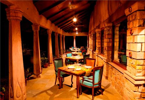 a wooden table and chairs on an outdoor patio at The Earth at Ranthambore in Sawāi Mādhopur