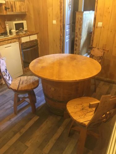 a kitchen with a table and two chairs and a barrel at gite du vieux bourg in Le Vieux Bourg