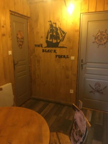 a room with a table and two doors at gite du vieux bourg in Le Vieux Bourg