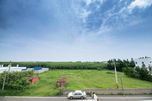 a car parked on a street with a grassy hill at 客拉客民宿 Clock B&B in Huxi
