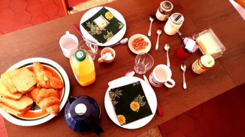 una mesa de madera con platos de comida. en Chambre privée dans maison centre-ville Sens Petit-déjeuner compris, en Sens