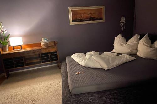 una cama con almohadas blancas en una habitación en Entspannt in Nürnberg - Das Einhörnchen, en Núremberg