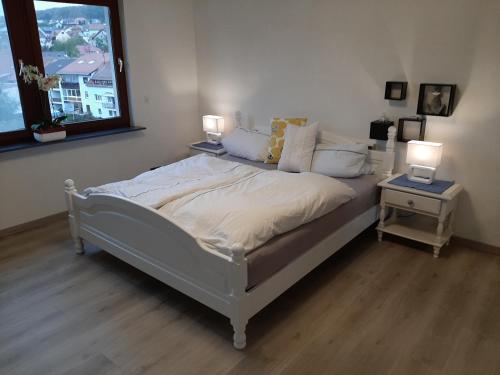 a bedroom with a bed with two lamps on it at Ferienwohnung Haus Gards in Marpingen