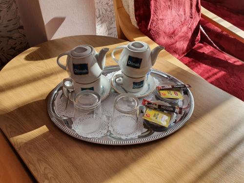 a tray with two tea pots and cups on a table at Hotel Sudety in Głuchołazy