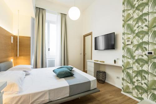 1 dormitorio con 1 cama y TV en la pared en NUMA ROMA GuestHouse en Roma