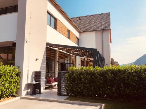 a building with a bench and some bushes at Na Vasi restavracija in prenočišča in Škofja Loka