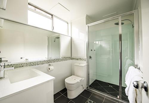 a bathroom with a sink and a toilet and a shower at Gympie Muster Inn in Gympie