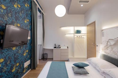 Un dormitorio con una cama y un televisor en una pared. en Numa Roma Guesthouse, en Roma