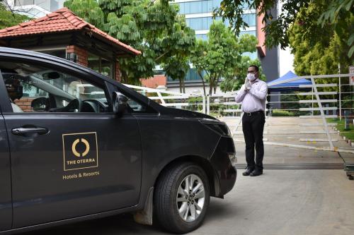 a man wearing a mask standing next to a car at The Oterra in Bangalore