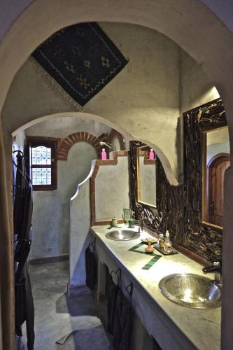 Baño con 2 lavabos en una habitación con arco en Sawadi Ecolodge, en Skoura