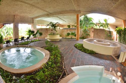 an outdoor pool with a hot tub in a building at TRS Yucatan Hotel - Adults Only in Akumal