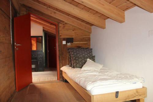 ein Schlafzimmer mit einem Bett und einer offenen Tür in der Unterkunft La Chujale in Arbaz
