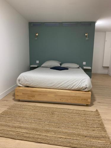 une chambre avec un lit avec une tête de lit bleue dans l'établissement Logement rénové et moderne au Sacré Coeur Cholet, à Cholet