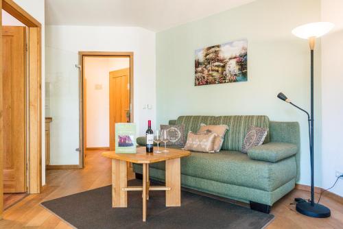 a living room with a green couch and a table at Ökotel Hamburg in Hamburg
