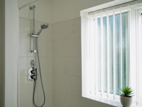 a shower in a bathroom with a window at Reddish comfort house in Manchester