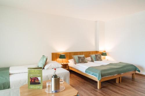 a bedroom with two beds and a table with a book at Ökotel Hamburg in Hamburg