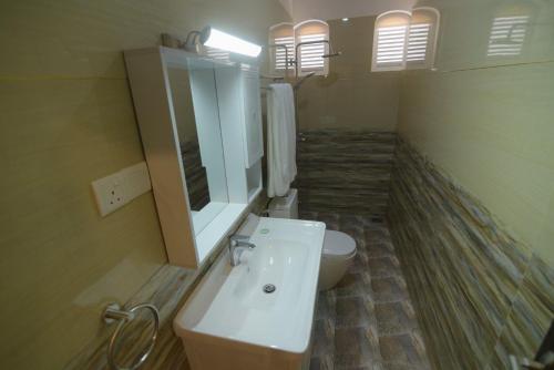 a bathroom with a white sink and a toilet at Hotel Blue Sky in Kurunegala