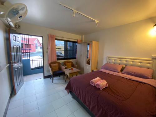 a bedroom with a bed and a chair and a window at Ban Pongphan in Chiang Mai