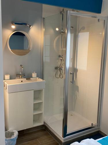 a bathroom with a shower and a sink at Maisonnette de la mer in Hermanville-sur-Mer