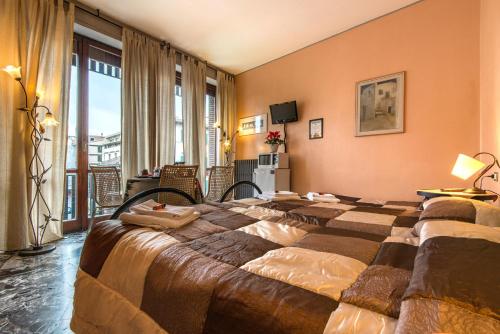 a hotel room with two beds and a balcony at Soggiorno Fortezza Fiorentina in Florence