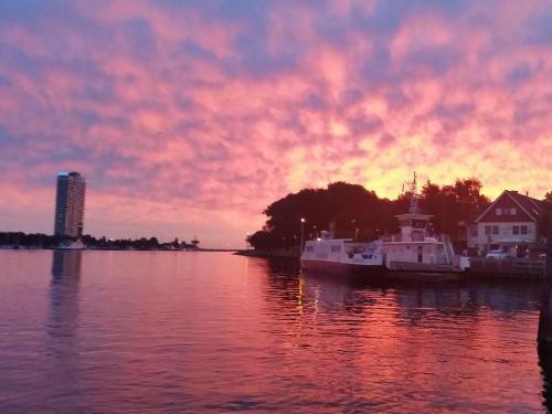 a sunset over a body of water with boats docked at Schwalbennest in Lübeck