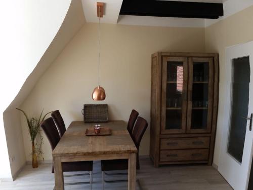 a dining room with a wooden table and chairs at Schwalbennest in Lübeck