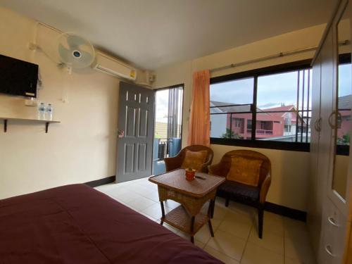 a bedroom with a bed and a table and a window at Ban Pongphan in Chiang Mai