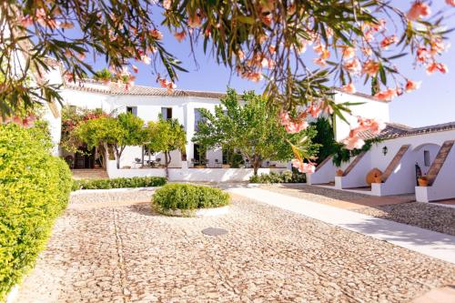 a villa with a garden and a driveway at Hotel Boutique Molino del Arco in Ronda