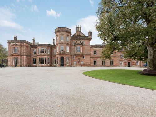 an old mansion with a large driveway in front of it at Netherby Hall in Carlisle